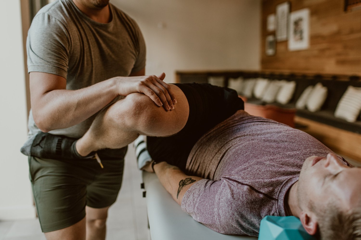 Chris supports a client's leg during a fully clothed FST session.