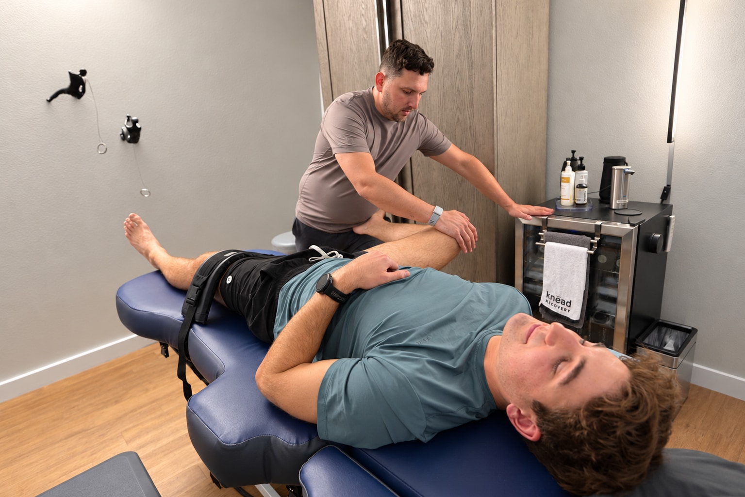 Chris supports Griffin Alpert’s bent leg during a clothed stretch session.
